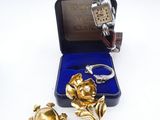 two pieces of jewelry are sitting in a box on a white surface