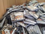 a cardboard box full of video games and dvds