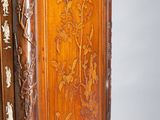 a tall wooden cabinet with a carved design on it