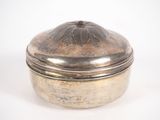 une boîte ancienne plaquée argent avec un couvercle bombé, sur fond blanc