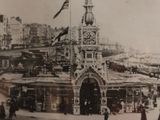 a black and white photo of a clock tower in the middle of a city
