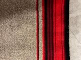 a close up of a red and beige rug on the floor