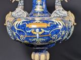 un vase bleu orné de deux oiseaux, posé sur une table