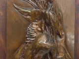 a bronze sculpture of a bird and a bird on a plaque