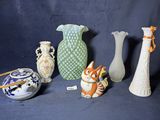cinq vases et une figurine de chat sur fond bleu