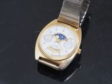 an image of a gold and silver watch on a black surface
