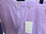 purple pants hanging on a hanger in a clothing store