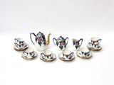 nine cups and a teapot sitting on a table