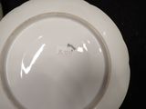 a white plate with a gold rim on a black table
