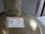 a silver vase with a tag on it sitting on a table