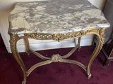 une table au plateau en marbre, surmontée d'un cadre doré