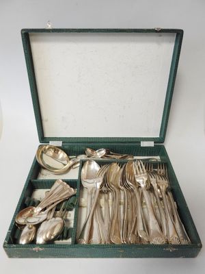 silverware in a green case on a white table