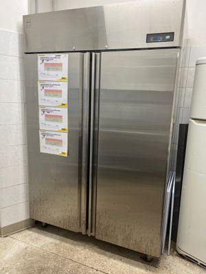 a stainless steel refrigerator in the corner of a kitchen