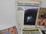 newspapers and magazines on a table with a camera on it