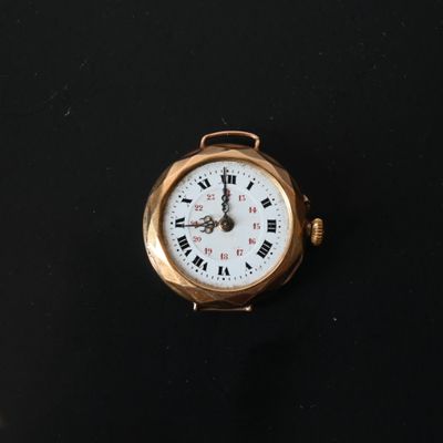 a small gold watch with roman numerals on the face