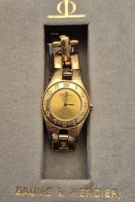 une photo d'une montre-bracelet en or dans un écrin