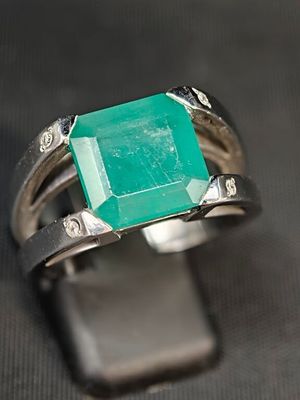 Gros plan sur une bague ornée d'une pierre verte