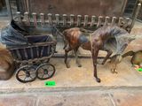 une statue représentant un cheval tirant une calèche, à côté d'un chien