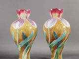 une paire de vases en céramique ornés de fleurs sur un fond gris