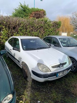 plusieurs voitures garées sur un parking, à côté de buissons et de buissons