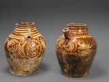deux vases marron posés côte à côte sur une surface grise