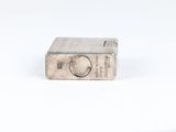 an old silver lighter sitting on top of a white surface