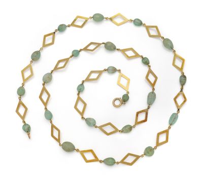 a close up of a long necklace with green beads on a white background