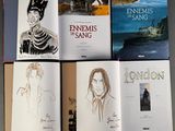 several books with pictures of people in costumes and a boat in the background