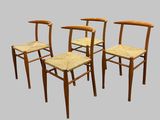 quatre chaises en bois avec des assises en osier sur fond gris