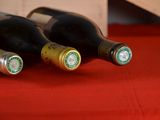 three bottles of wine sitting on a red table