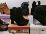 Plusieurs paires de bottes pour femmes sont empilées sur des cartons