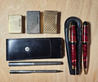 un portefeuille, un stylo, un briquet, un briquet et d'autres objets posés sur une table
