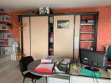 a desk with a computer and a chair in a room