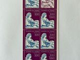 a stamp with a picture of a woman sitting on a bench