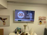 a television mounted on the wall above a desk in a room