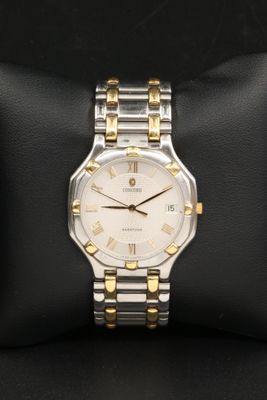 a close up of a watch sitting on a pillow on a black surface