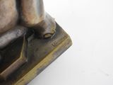 a bronze statue of a man with a gun on it