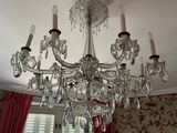 a chandelier in the middle of a room with red curtains