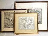 three framed maps of the world on a shelf in a room