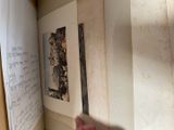 a hand that is holding a piece of paper in front of a book