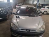 a silver car parked in a garage with other cars in the background