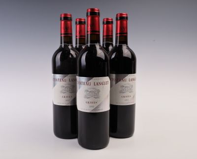 trois bouteilles de vin rouge posées sur une table blanche