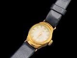 une image d'un gros plan d'une montre-bracelet sur une surface noire
