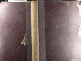 an old book with a bookmark on it sitting on top of a table