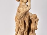 statue d'une femme tenant un enfant dans ses bras, posée sur une surface blanche