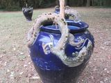 un vase bleu orné d'un dragon, posé dans l'herbe