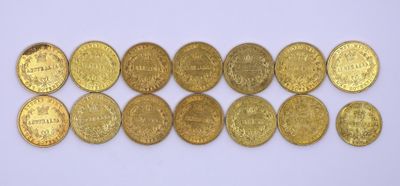 un tas de pièces d'or posé sur une surface blanche