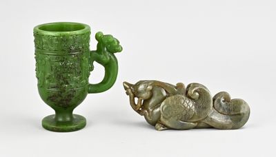 un vase vert et une petite statue placés l'un à côté de l'autre