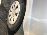a white car with a flat tire on the side of the road