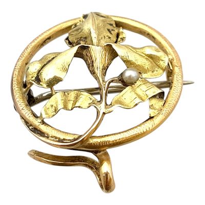 une image représentant une broche en or ornée de feuilles et d'une perle